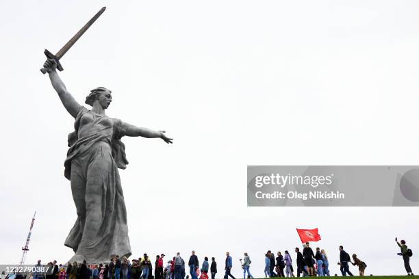 People at the Motherland Calls monument mark the 76th anniversary of the victory over Nazi Germany in World War II on May 9, 2021 in Volgograd,...