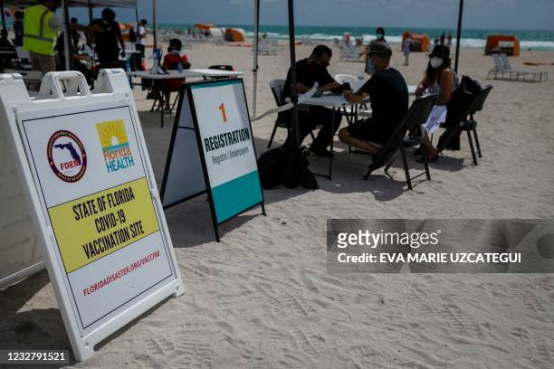 People check in to get Johnson & Johnson Covid-19 vaccine at a pop-up vaccination center at the beach, in South Beach, Florida, on May 9, 2021.