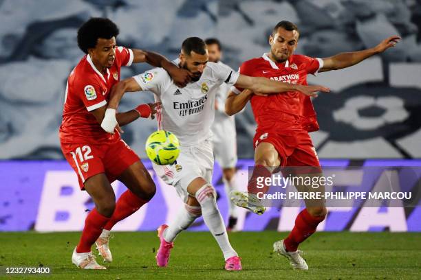 Real Madrid's French forward Karim Benzema vies with Sevilla's French defender Jules Kounde and Sevilla's Spanish midfielder Joan Jordan Moreno...