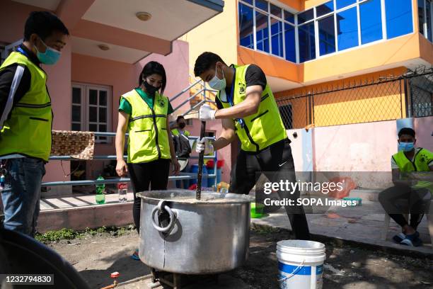Nepalese Youth Volunteers representing 'Animal welfare Nepal' prepare food for the stray dogs during the 11th day of the Prohibitory order due to a...