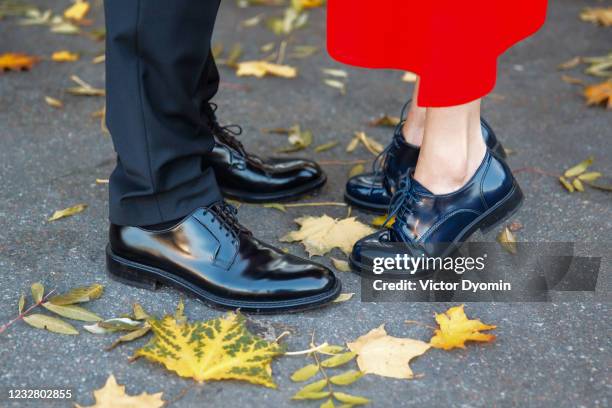 male and female legs in the fall - zapato de cuero fotografías e imágenes de stock