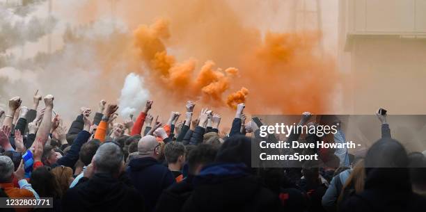 Blackpool fans outside the stadium celebrate reaching the division one play-offs by setting off flares during the Sky Bet League One match between...