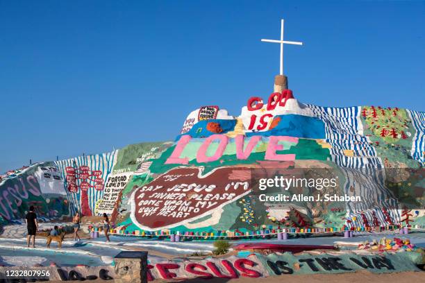 Slab City, CA Tourist visit Salvation Mountain, hillside Christian monument paying homage to Jesus Christ and was created by the late resident...