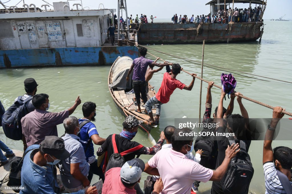 Migrant people climb on a rope as they try to get into an...
