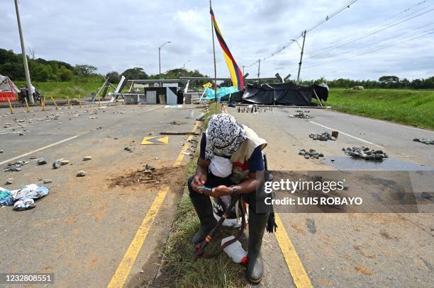 An indigenous demonstrator looks at his mobile phone near a barricade blocking the Panamerican highway during a protest against the government...