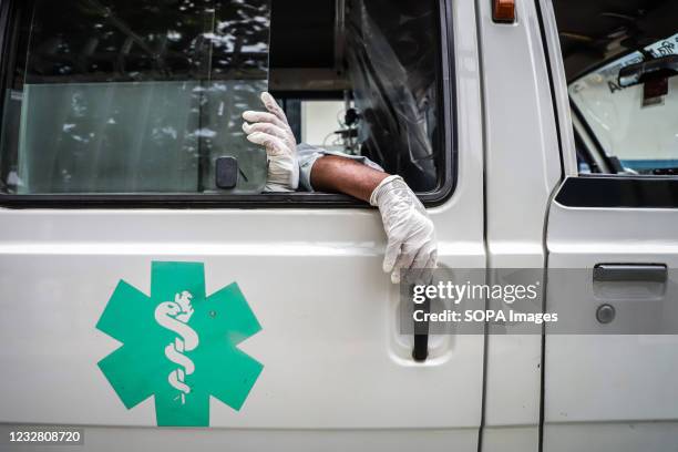 Hands of the Covid-19 positive patient who waits in an ambulance outside of a COVID-19 care hospital, as many of the hospitals are not able to...