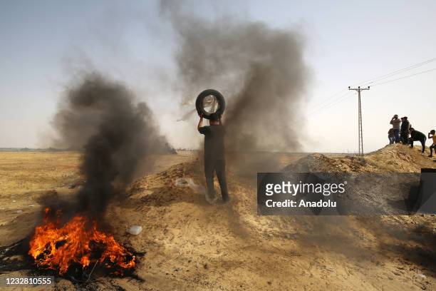 Palestinians burn tires against interventions of Israeli forces during a demonstration to protest attacks by Israeli police with tear gas, rubber...