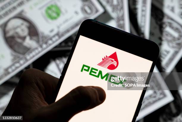 In this photo illustration the Mexican oil and gas company Petróleos Mexicanos, better known as Pemex, logo seen displayed on a smartphone with USD...