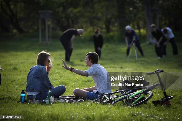 People are seen enjoying the warm weather in the Pole Mokotowskie park in Warsaw, Poland on May 10, 2021.