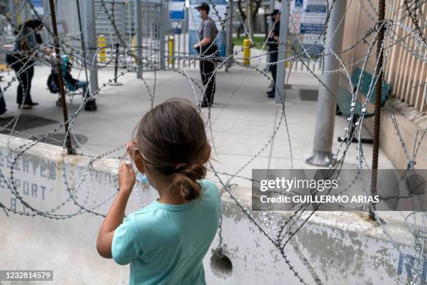 Migrant girl looks at asylum seekers entering the United States at the San Ysidro crossing port in Tijuana, Baja California State, Mexico, on May 10,...