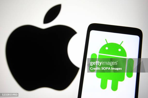 In this photo illustration the Android logo of a mobile operating system is seen on a smartphone screen with an Apple logo in the background.