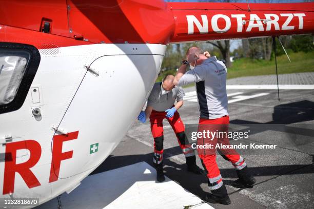 Sven Reinecke and emergency doctor Martin Fleiderer prepare to take a patient at AIRBUS H145 of DRF Luftrettung emergency air medical services at...