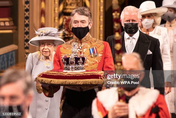 Queen Elizabeth II follows the imperial state crown along the royal gallery, whilst being escorted by Prince Charles, Prince of Wales during the...
