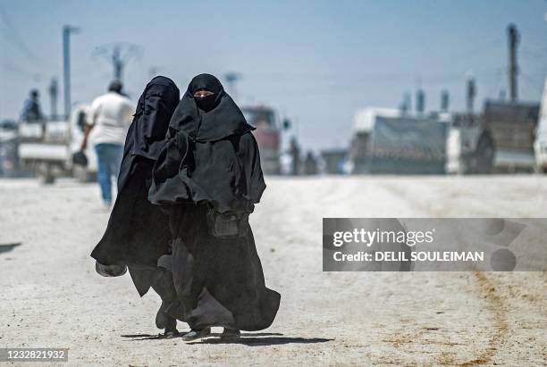 Women walk by as another group of Syrian families is released from the Kurdish-run Al-Hol camp, which holds relatives of suspected Islamic State...