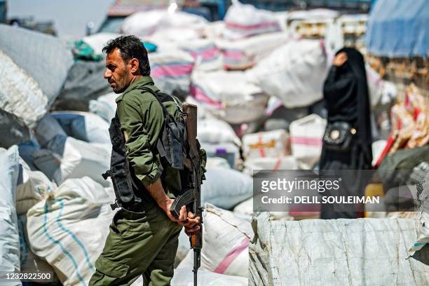 Member of Kurdish security stands guard amid preparations for departure as another group of Syrian families is released from the Kurdish-run Al-Hol...