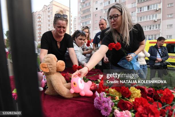 Woman places a toy at a makeshift memorial for victims of the shooting at School No. 175 in Kazan on May 11, 2021. - At least nine people, most of...