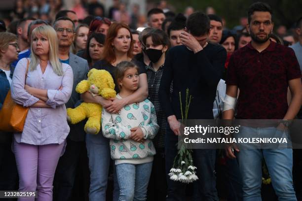 People gather to lay flowers and toys at a makeshift memorial for victims of the shooting at School No. 175 in Kazan on May 11, 2021. - At least nine...