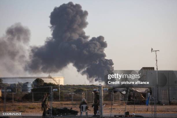 May 2021, Israel, Ashkelon: Thick smoke is seen rising from the premises of the Trans-Israel pipeline, after rockets were fired overnight by the...