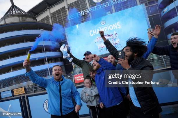 Manchester City fans celebrate outside Etihad Stadium as their team has been confirmed as Premier League champions for the third time in four seasons...