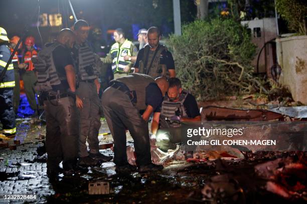 Israeli security forces inspect wreckage at the entrance of the central city of Tel Aviv, on May 11 after rockets were launched towards Israel from...