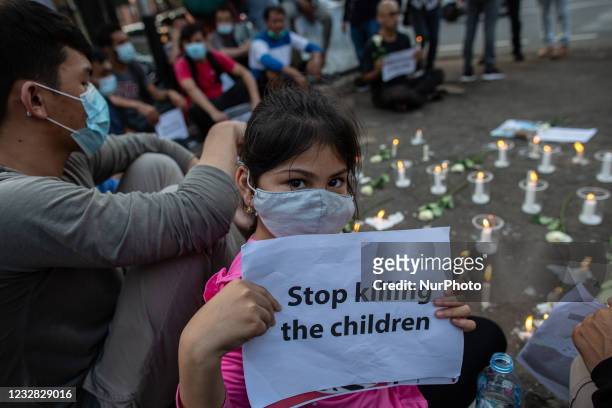 Little girl of refugees members of the Shiite Hazara community carries a placards to show solidarity with the victims of Kabul school bombing,...