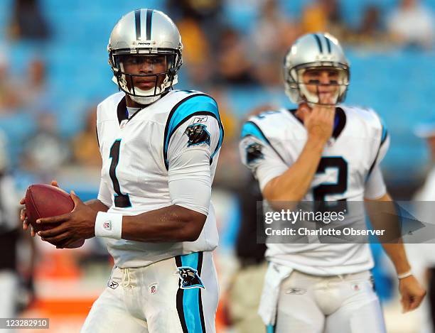 Carolina Panthers rookie quarterback Cam Newton prepares to pass to a receiver as incumbent quarterback Jimmy Clausen looks on during drills at Bank...