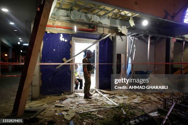 Israeli security inspect a building whose facade was damaged in Holon near Tel Aviv, on May 11 after rockets were launched towards Israel from the...