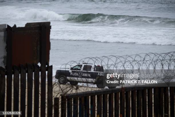 Mexican police vehicle drives on the beach along the US-Mexico border between San Diego and Tijuana as it ends in the Pacific Ocean during a tour...