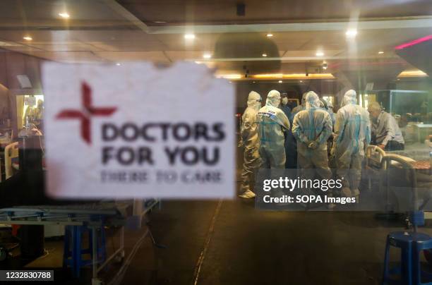 Doctors and healthcare staff wearing Personal Protective Equipment suits attend to Covid-19 patient inside a Covid-19 care center set up at Shehnai...