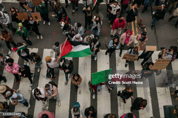 Protesters demanding an end to Israeli aggression against Palestine march in the street in Midtown Manhattan on May 11, 2021 in New York City. Recent...