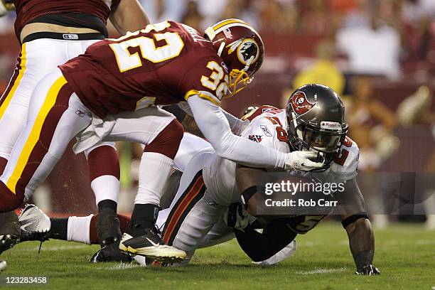 Running back Kregg Lumpkin of the Tampa Bay Buccaneers is brought down at the goal line by safety Anderson Russell of the Washington Redskins during...