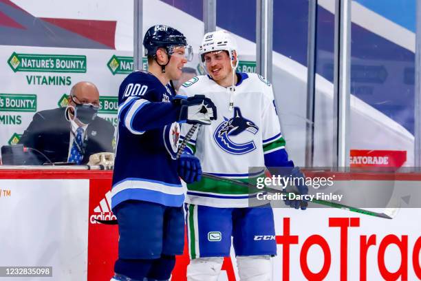 Paul Stastny of the Winnipeg Jets and Nate Schmidt of the Vancouver Canucks share a laugh during the pre-game warm up prior to NHL action at the Bell...