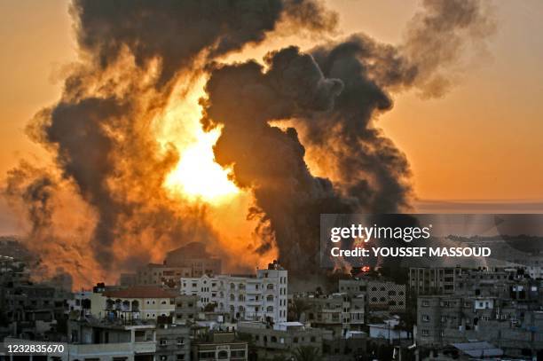 Fire rages at sunrise in Khan Yunish following an Israeli airstrike on targets in the southern Gaza strip, early on May 12, 2021. - Israeli air raids...