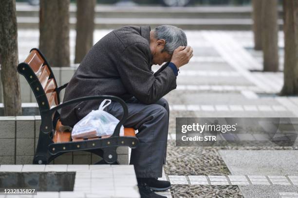 An elderly man rests at a park in Fuyang in China's eastern Anhui province on May 12, 2021. - China OUT / China OUT