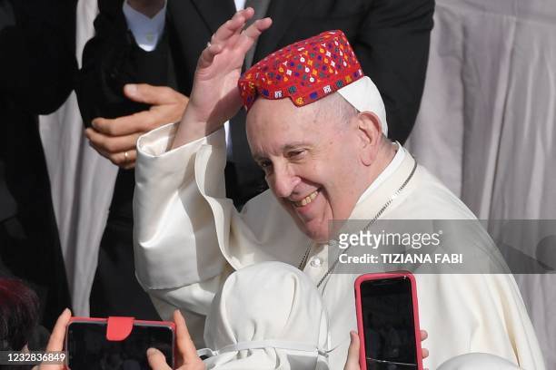 Pope Francis tries on a hat from the Philippines as he arrives on May 12, 2021 at San Damaso courtyard in The Vatican to resume his weekly outdoors...