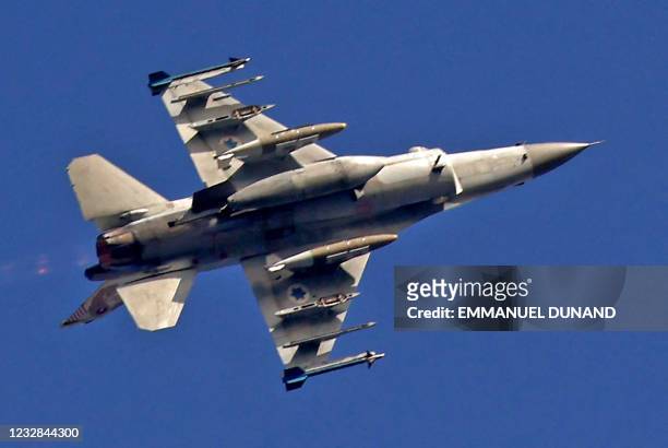 An Israeli F16 warplane flies over the southern Israeli city of Ashdod, as air strikes on Gaza continue, on May 12, 2021. - Israeli air raids in the...
