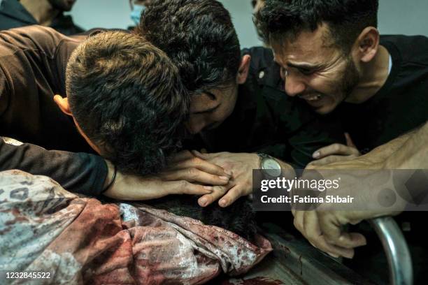 Relatives of Palestinian Izz al-Deen Helles during his bid farewell at Al-Shifa Hospital, after he was killed during an Israeli raid east of Gaza...