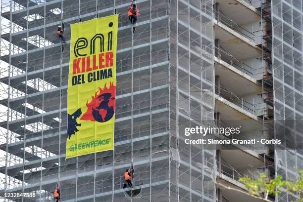 Greenpeace activists unfurl a large banner in front of ENI's headquarters, during ENI's shareholders' meeting, to demonstrate the dramatic impacts of...