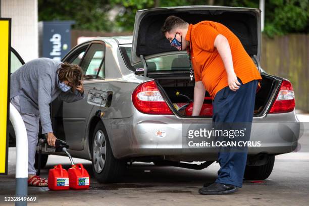 Motorists fill up gas cans at a Shell station in Charlotte, North Carolina on May 12, 2021. - Fears the shutdown of the Colonial Pipeline because of...