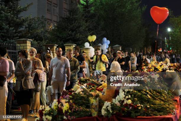 People bring flowers to a memorial set up at the scene of a shooting at Secondary School No 175 in Tatarstan's capital Kazan in Russia, on May 12,...