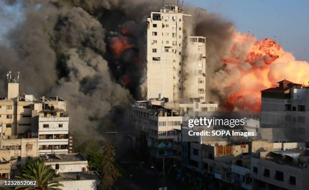 Smoke and flames rise from a tower building destroyed by Israeli air strikes amid a flare-up of Israeli-Palestinian violence in Gaza City Israel...