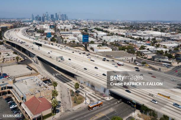 In this aerial image, vehicles drive on the 110 Freeway approaching the downtown Los Angeles skyline on May 12, 2021 in Los Angeles, California.