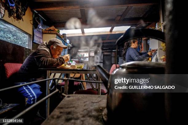 Abraham Morales eats near his wife Rosa Guinez at the kitchen of their house of the Pedro del Rio Zanartu camp in Concepcion, Chile, on April 29,...