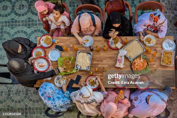 Filipino Muslims eat a meal together as they celebrate Eid al-Fitr at the Garden Mosque on May 13, 2021 in Taguig, Metro Manila, Philippines. Eid...