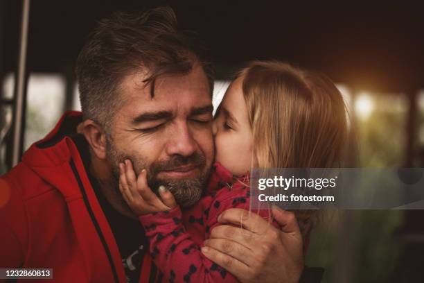 aanbiddelijk meisje dat haar houdende vader kust - kissing kids stockfoto's en -beelden