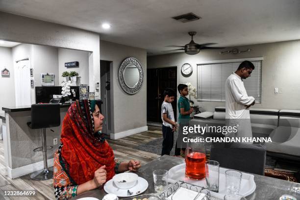 Businessman Zeshan Sheikh , originally from Pakistan, with his two son Subhan Sheikh Amaan Sheikh offer namaz as wife Sehar Sheikh looks on after...
