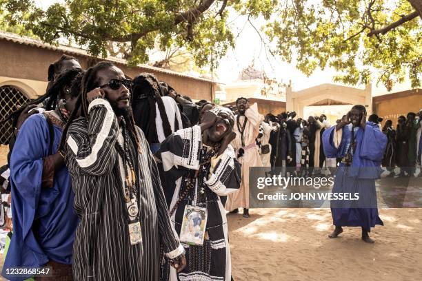 Men of the Baye Fall sect gather to chant ahead Eid al-Fitr, which marks the end of the holy month of Ramadan, in Mbacke on May 13, 2021. - The Baye...
