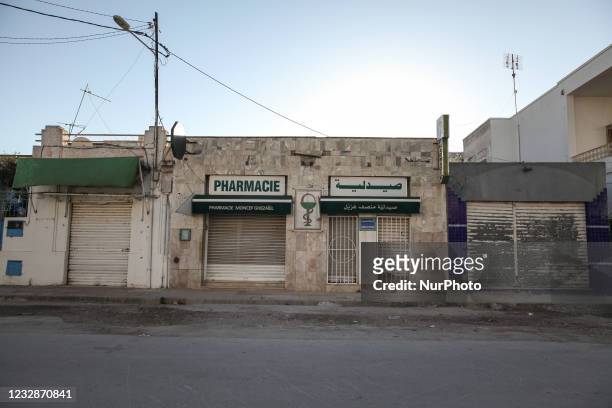 Pharmacy with closed doors in an empty street in the city of Ariana, Greater Tunis area, Tunisia on May 13, 2021. As Muslims around the world...