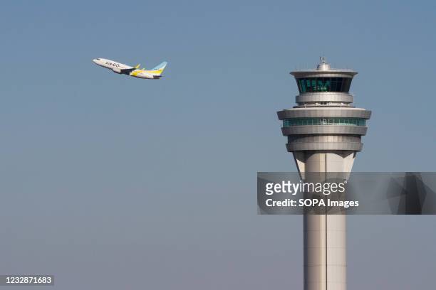 Boeing 737-700 with regional airline, Air Do takes off behind the Control Tower at Haneda International Airport.