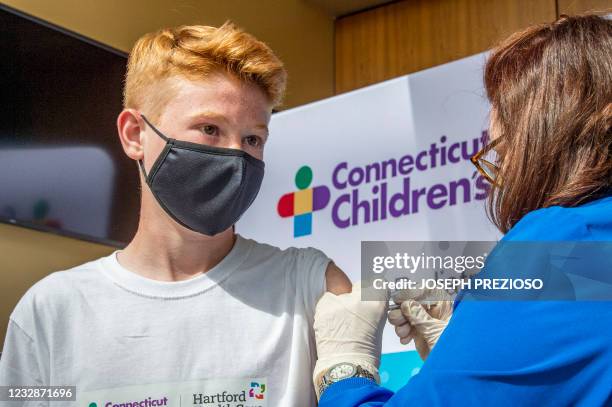 Robert Riccoban, age 13, is inoculated by a Nurse at Hartford Healthcare's mass vaccination center at the Connecticut Convention Center in Hartford,...